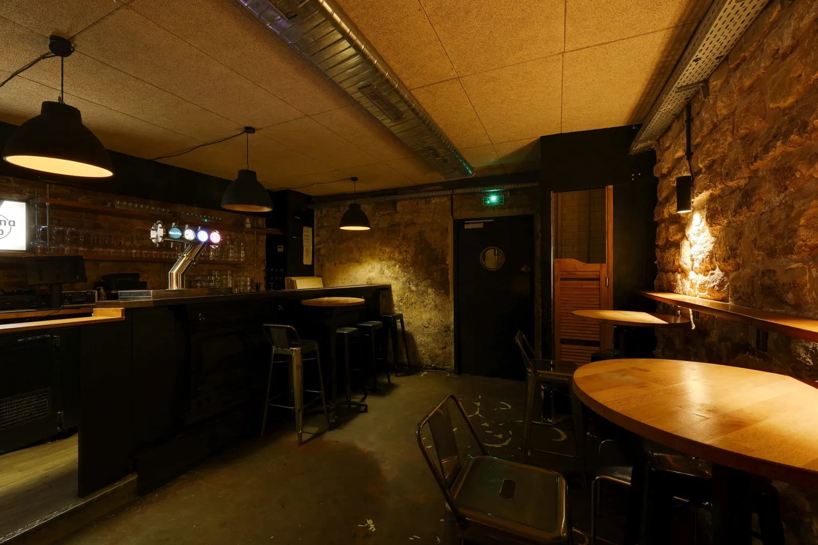La cave de La Morézienne, tables et tabourets face à la scène