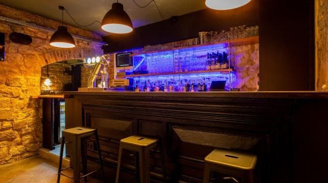La salle de La Morezienne en lumière de soirée, comptoir en pierre de taille